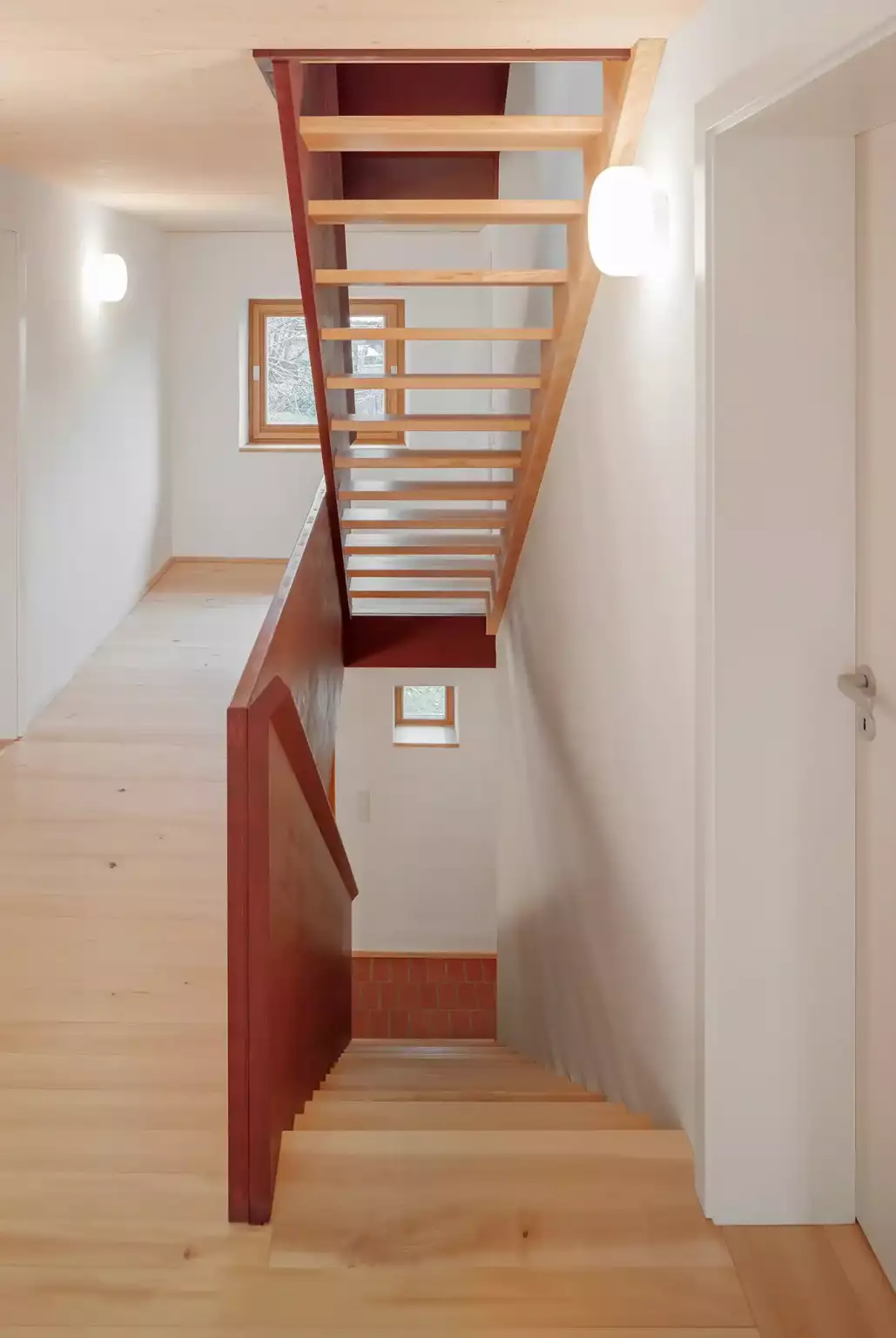 Treppe aus massiver Esche mit rotem Brettgeländer