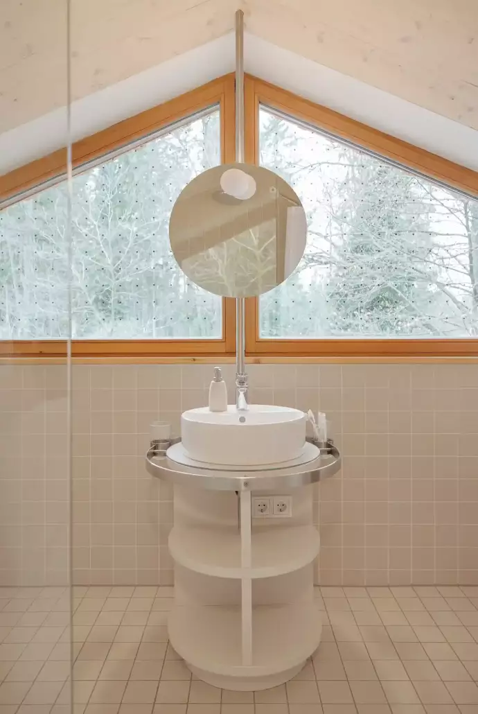 Bad im umgebauten Dachgeschoß mit hellen Fliesen und rundem Waschbecken